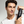 Man holding a bottle of 'Mr. Jones Conditioner' conditioner against a grey background