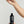 MR. JONES Grey Defence Serum bottle with dropper held by a hand against a light grey background