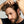 Man placing dropper bottle of Hair Density Serum into his hair against a neutral background