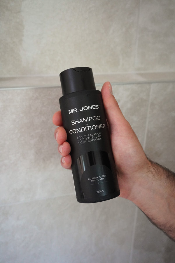 men's hand holding Mr Jones Shampoo + Conditioner 2-in-1