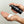 Hand holding a black bottle labeled 'Mr. Jones Beard Wash' with foam on a light gray background