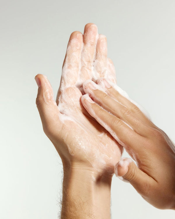Hands with Beard Wash foam against a light background